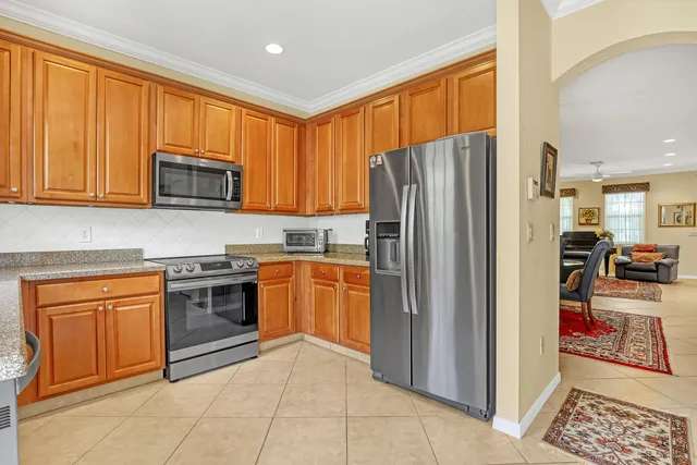 a kitchen with stainless steel appliances granite countertop a refrigerator and a stove top oven