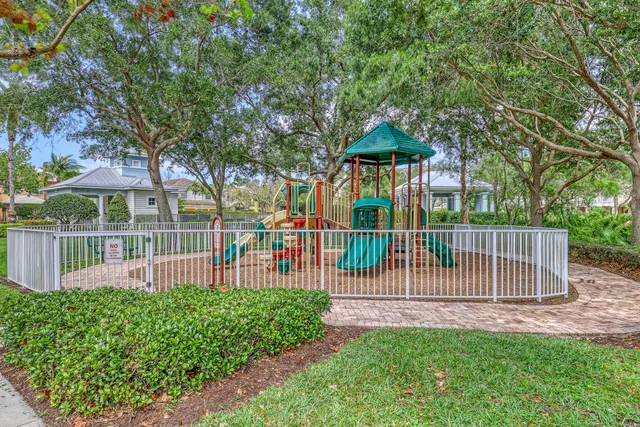 a view of a house with a small yard and a large tree