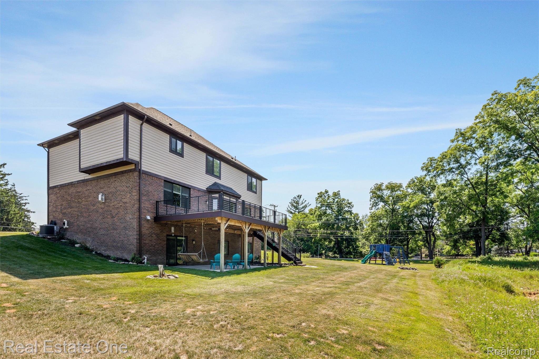 2983 28 Mile Road Washington, MI 48094 - Photo 44 of 54 Brick and siding exterior featuring a multi-level deck with black railings and a walk-out lower level