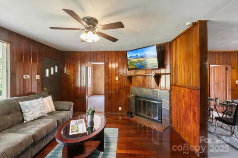 a living room with furniture a fireplace and a chandelier