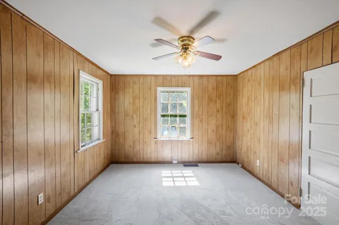 a view of an empty room with a window and closet area