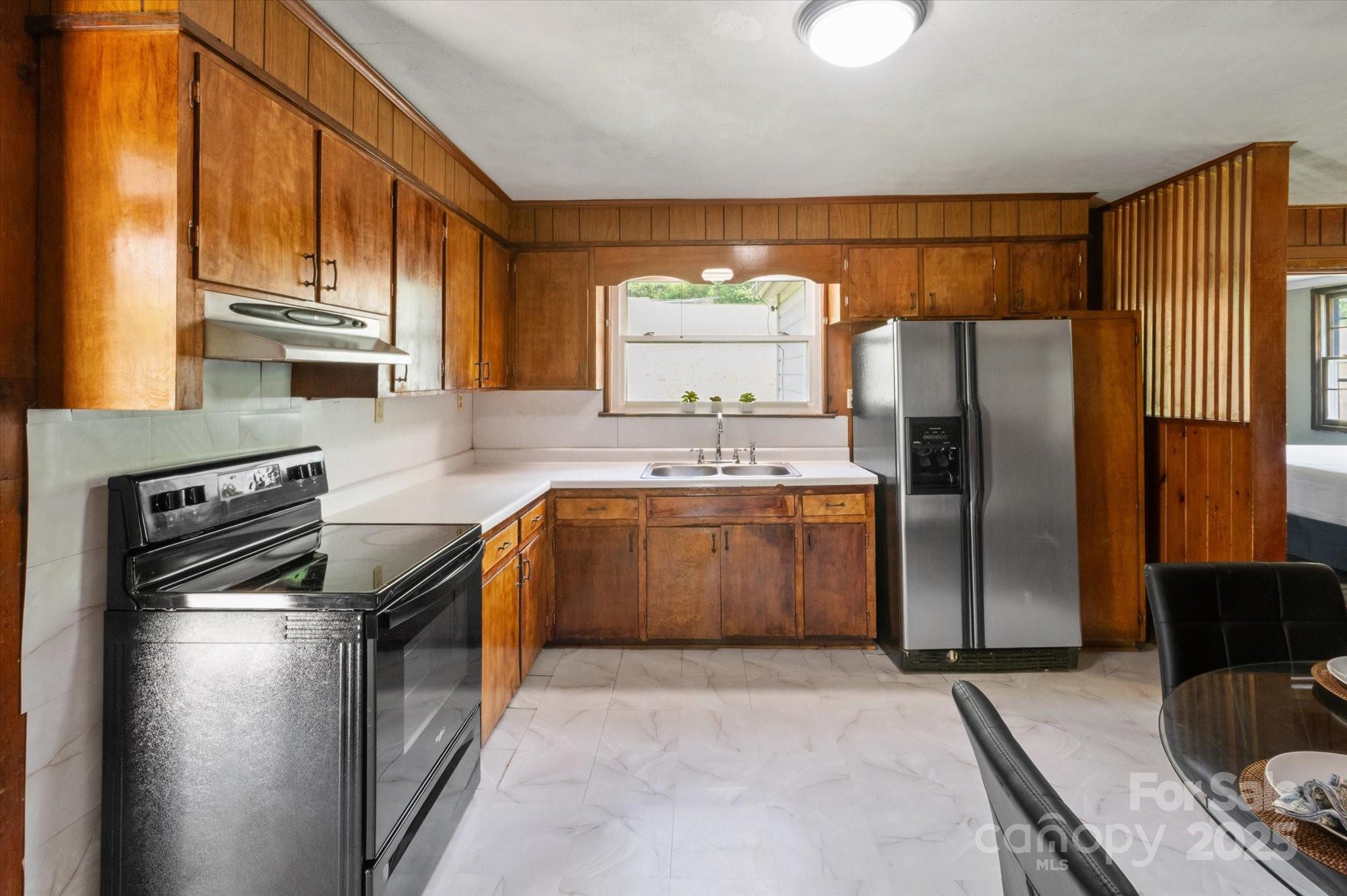 35 Homeway Road Asheville, NC 28806 - Photo 21 of 32 a kitchen with stainless steel appliances granite countertop a refrigerator a stove and a sink with large window
