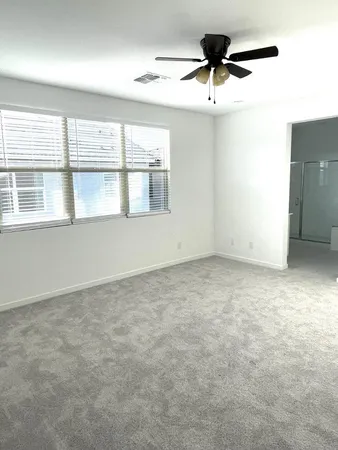 an empty room with a window and a ceiling fan