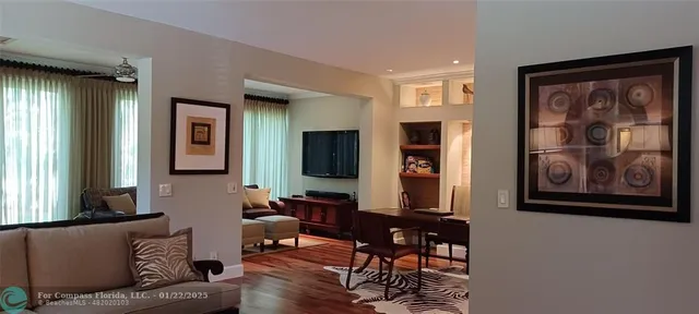 a living room with furniture a window and a flat screen tv