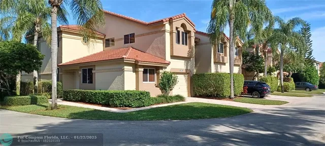 a view of a white house with a small yard and plants