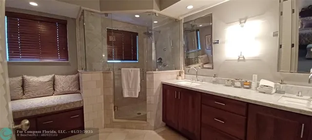 a en suite bathroom with a double vanity sink a mirror and a shower