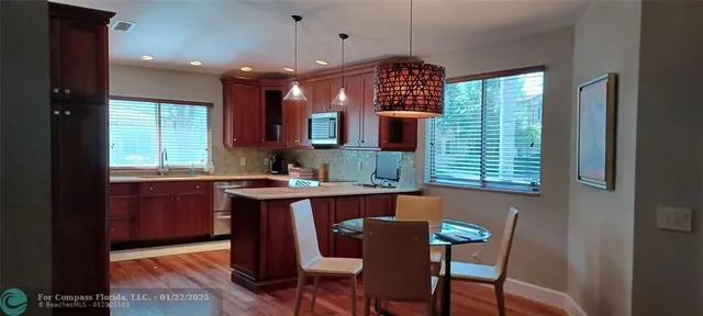 a kitchen with a table chairs sink and cabinets