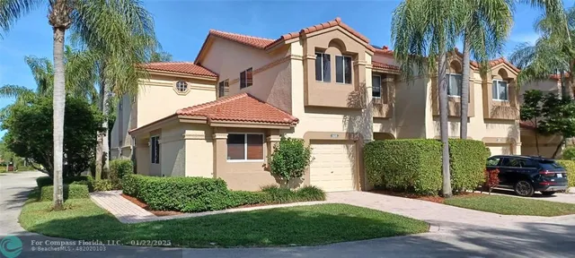a front view of a house with a yard and potted plants