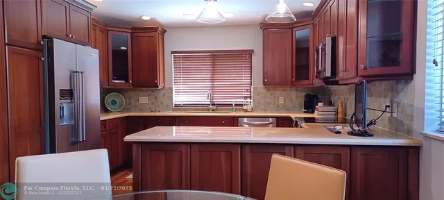 a kitchen with a sink a refrigerator and cabinets
