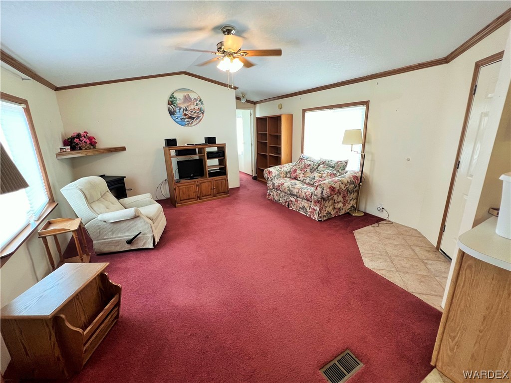 2336 South Rease Road Kingman, AZ 86401 - Photo 13 of 41 Living room with carpet floors, crown molding, ceiling fan, and vaulted ceiling