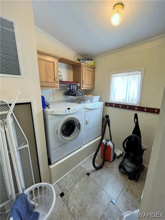 2336 South Rease Road Kingman, AZ 86401 - Photo 14 of 41 Laundry room with light tile floors, a textured ceiling, crown molding, cabinets, and washer and clothes dryer