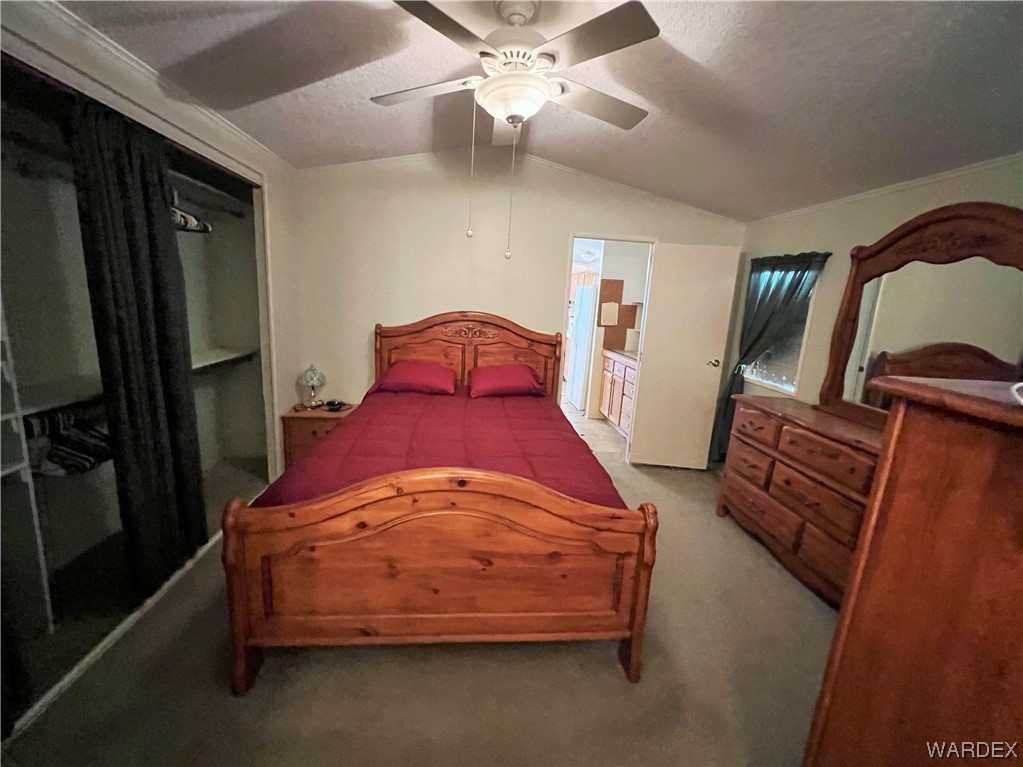 2336 South Rease Road Kingman, AZ 86401 - Photo 15 of 41 Carpeted bedroom featuring lofted ceiling, ceiling fan, and a textured