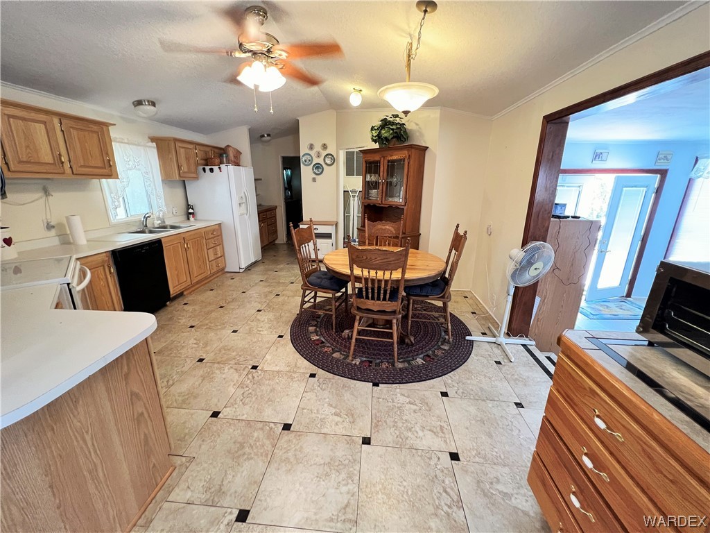 2336 South Rease Road Kingman, AZ 86401 - Photo 5 of 41 Tiled dining space featuring ornamental molding, sink, and ceiling fan