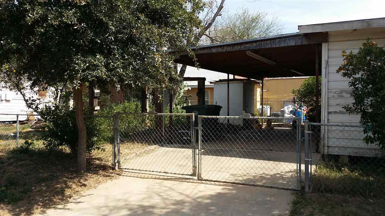 1102 Willow Street Laredo, TX 78040 - Photo 5 of 6 a view of a patio with table and chairs under an umbrella with large tree