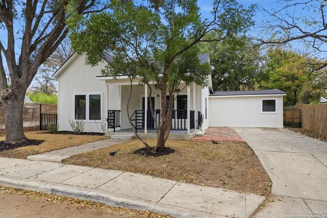 a view of a house with backyard and trees
