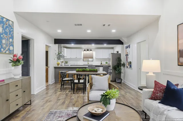 a living room with furniture kitchen view and a potted plant