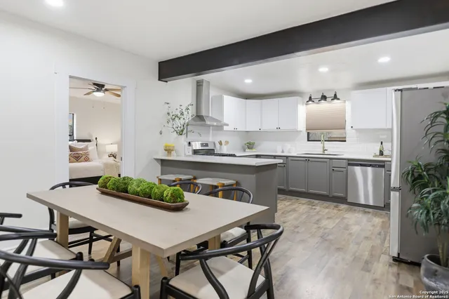 a kitchen with kitchen island a dining table and chairs