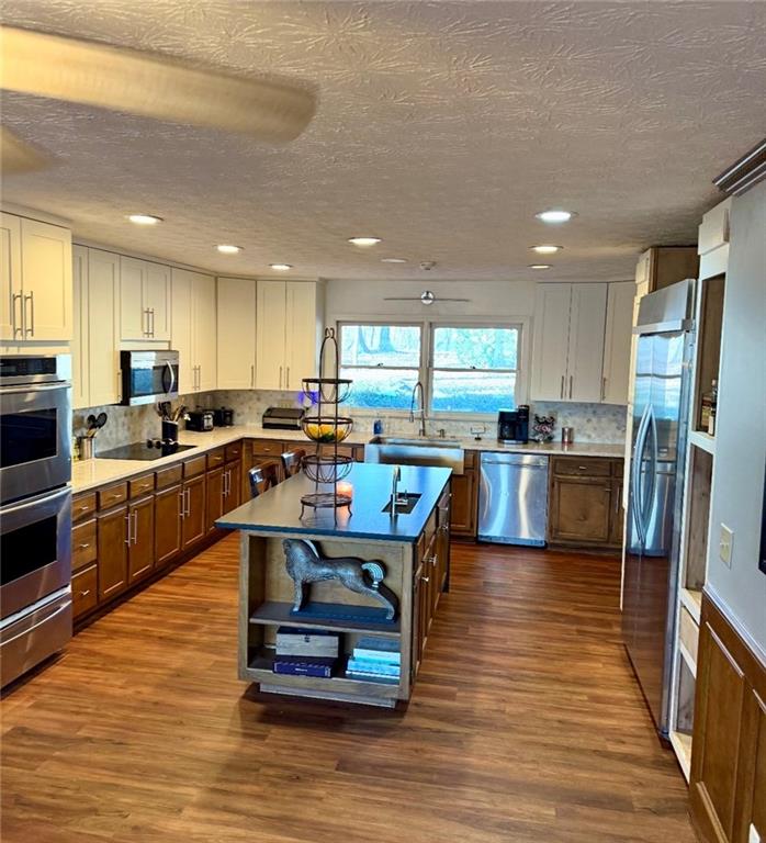 4570 Settles Bridge Road Suwanee, GA 30024 - Photo 4 of 21 a kitchen with stainless steel appliances granite countertop wooden cabinets a sink a stove a refrigerator and cabinets