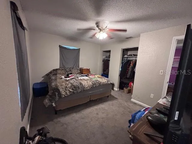 an empty room with a window and a ceiling fan