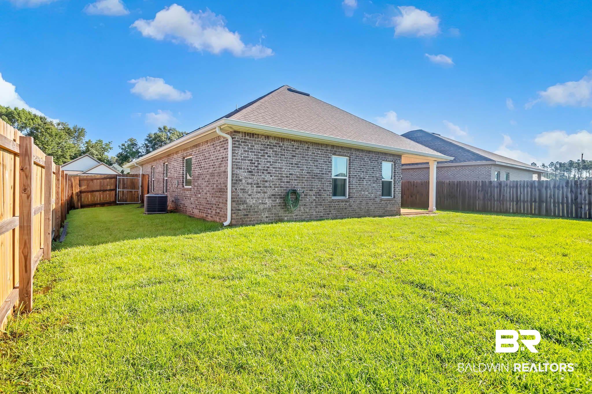 16461 Prado Loop Loxley, AL 36551 - Photo 64 of 78 Back of house with a fenced backyard, brick siding, and a shingled roof
