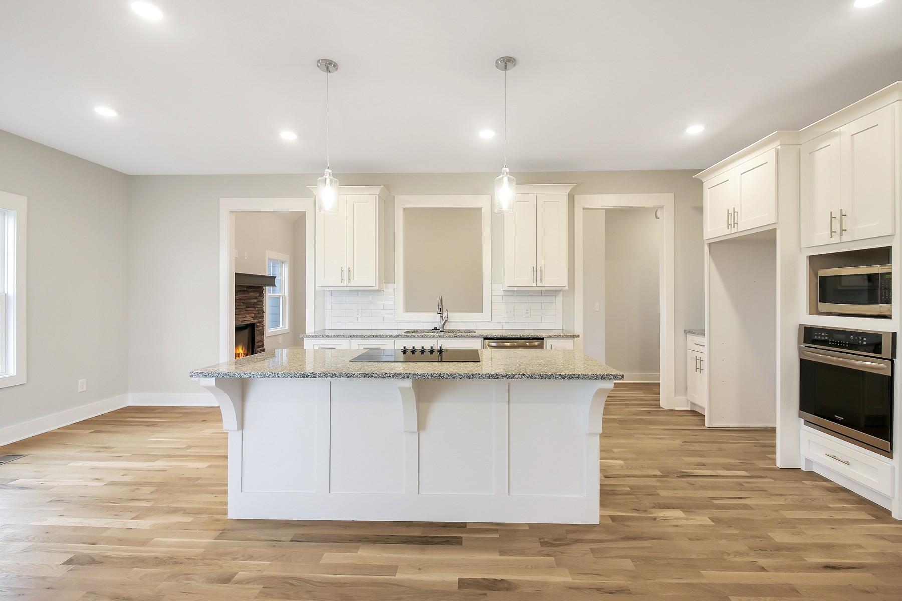 4889 Barren Plains Road Springfield, TN 37172 - Photo 5 of 17 a view of a kitchen with kitchen island granite countertop a stove a sink a refrigerator and white cabinets with wooden floor