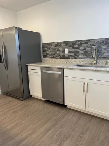 an empty room with wooden floor and cabinet