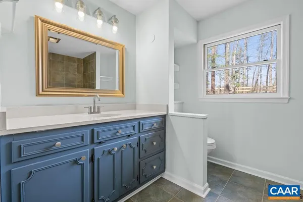 a bathroom with a sink mirror and a window