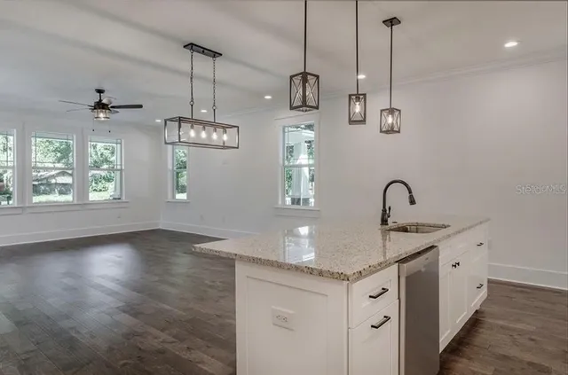 a kitchen with granite countertop white cabinets and stainless steel appliances
