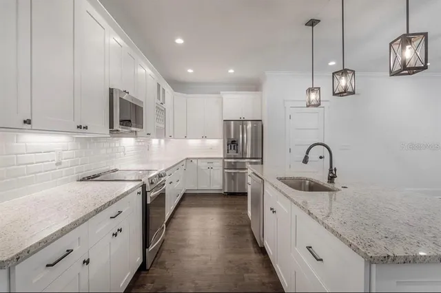 a kitchen with a sink cabinets and stainless steel appliances