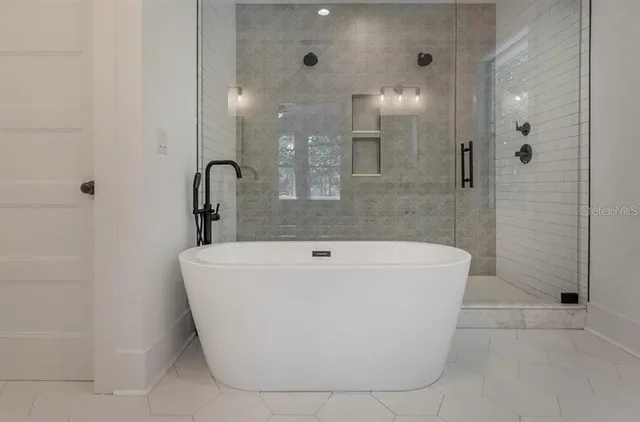 a bathroom with a tub sink and mirror