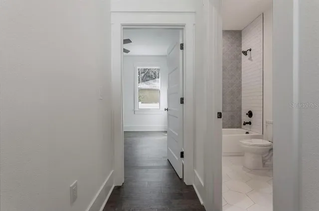 a bathroom with a granite countertop toilet a sink and a bathtub