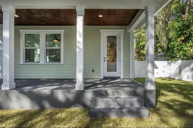 a view of a yard in front of a house with a large tree