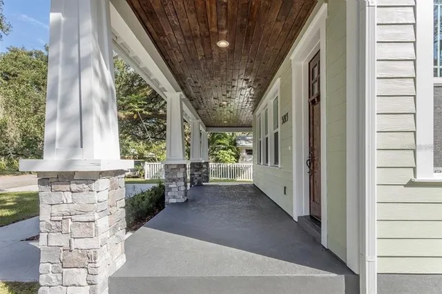 a view of a hallway with stairs and wooden floor
