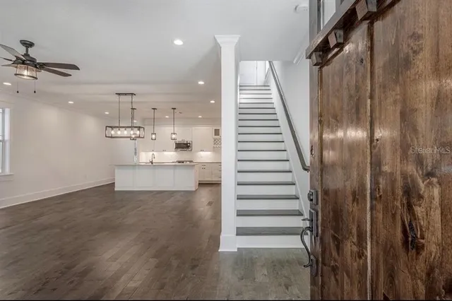 a large white kitchen with kitchen island a stove a sink dishwasher and a oven with white cabinets