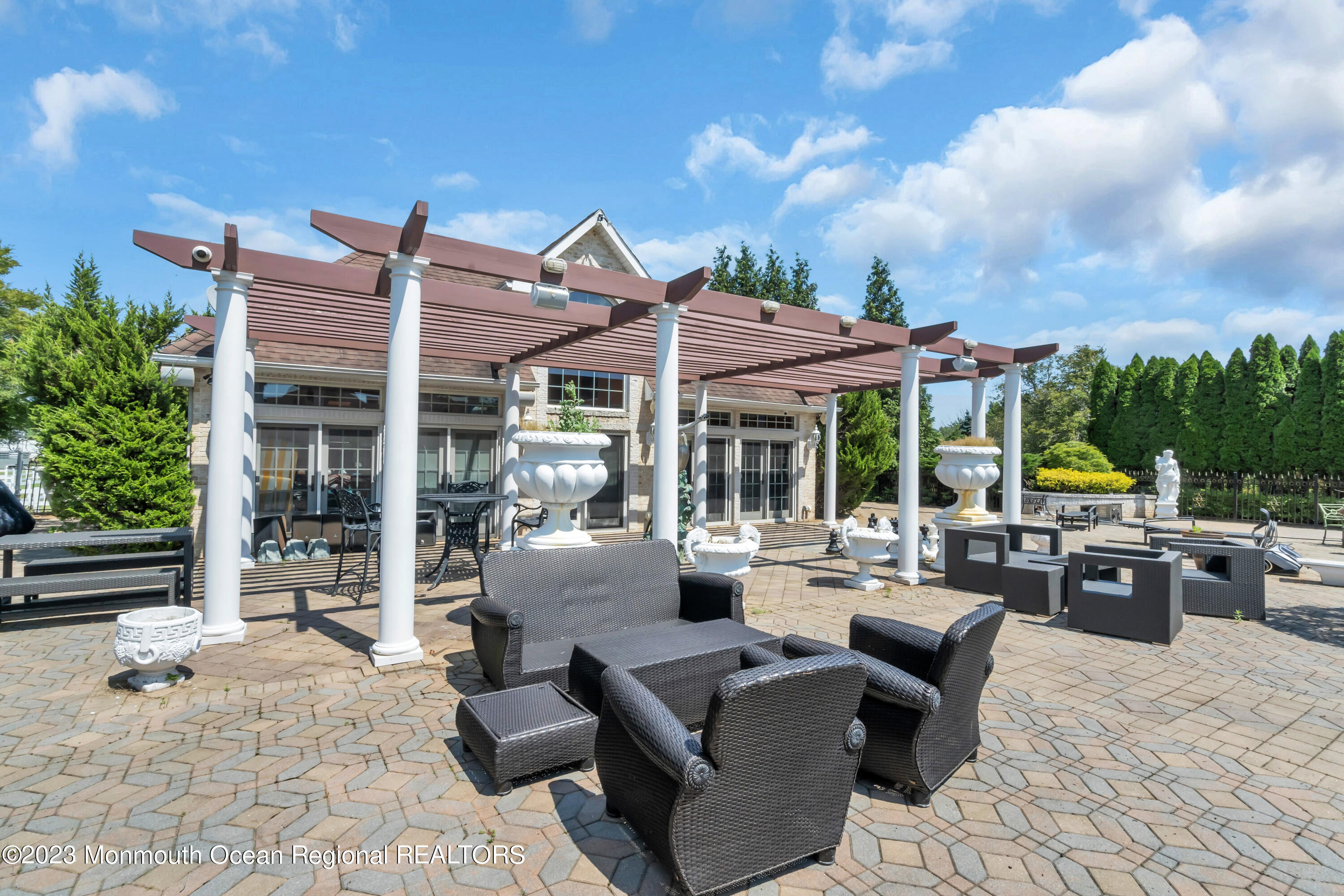 2 Bluebell Road Colts Neck, NJ 07722 - Photo 56 of 80 a view of a patio with a dining table and chairs with wooden floor