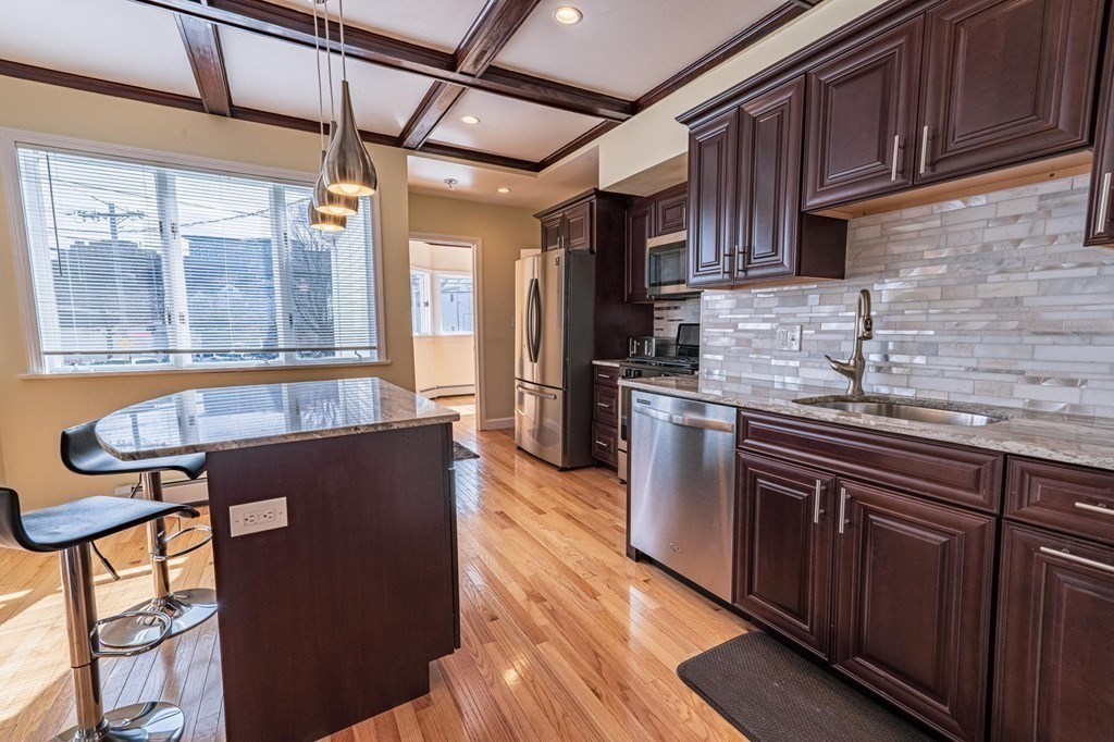 12 Jones Avenue, Unit 1 Chelsea, MA 02150 - Photo 3 of 17 a kitchen with stainless steel appliances granite countertop a refrigerator a sink dishwasher a stove and white countertops with cabinets