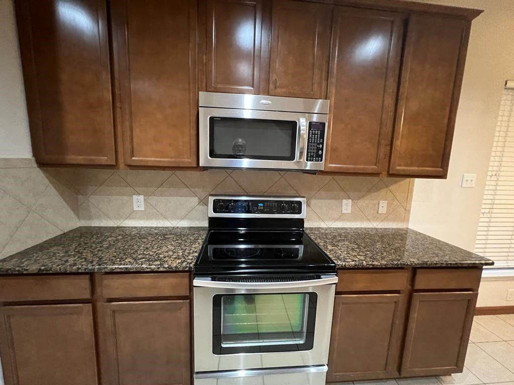 411 Stream Mill Lane Katy, TX 77494 - Photo 11 of 29 a kitchen with granite countertop stainless steel appliances and wooden cabinets