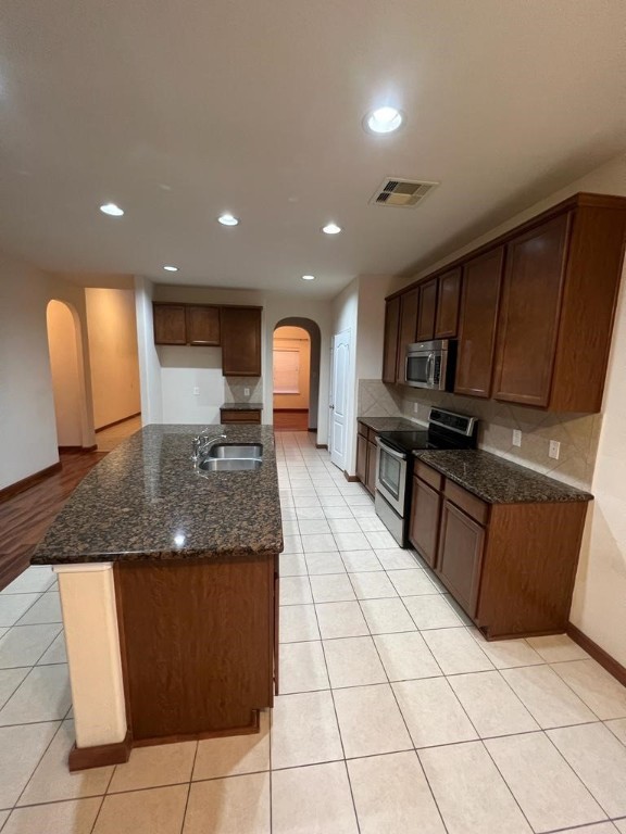 411 Stream Mill Lane Katy, TX 77494 - Photo 10 of 29 a kitchen with granite countertop a stove a sink and a microwave