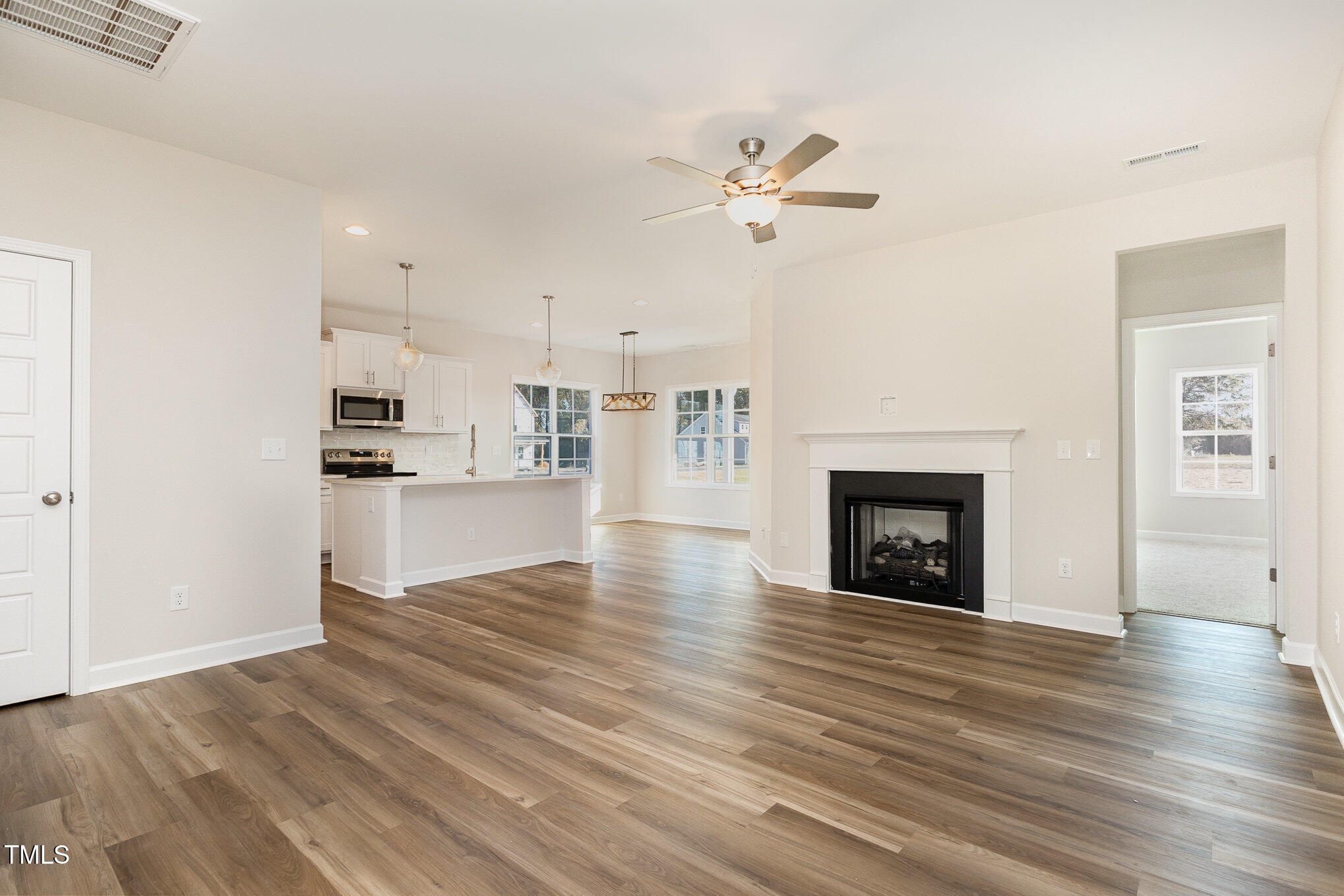 15 Barony Lane Smithfield, NC 27577 - Photo 6 of 24 a view of a kitchen and an empty room with wooden floor