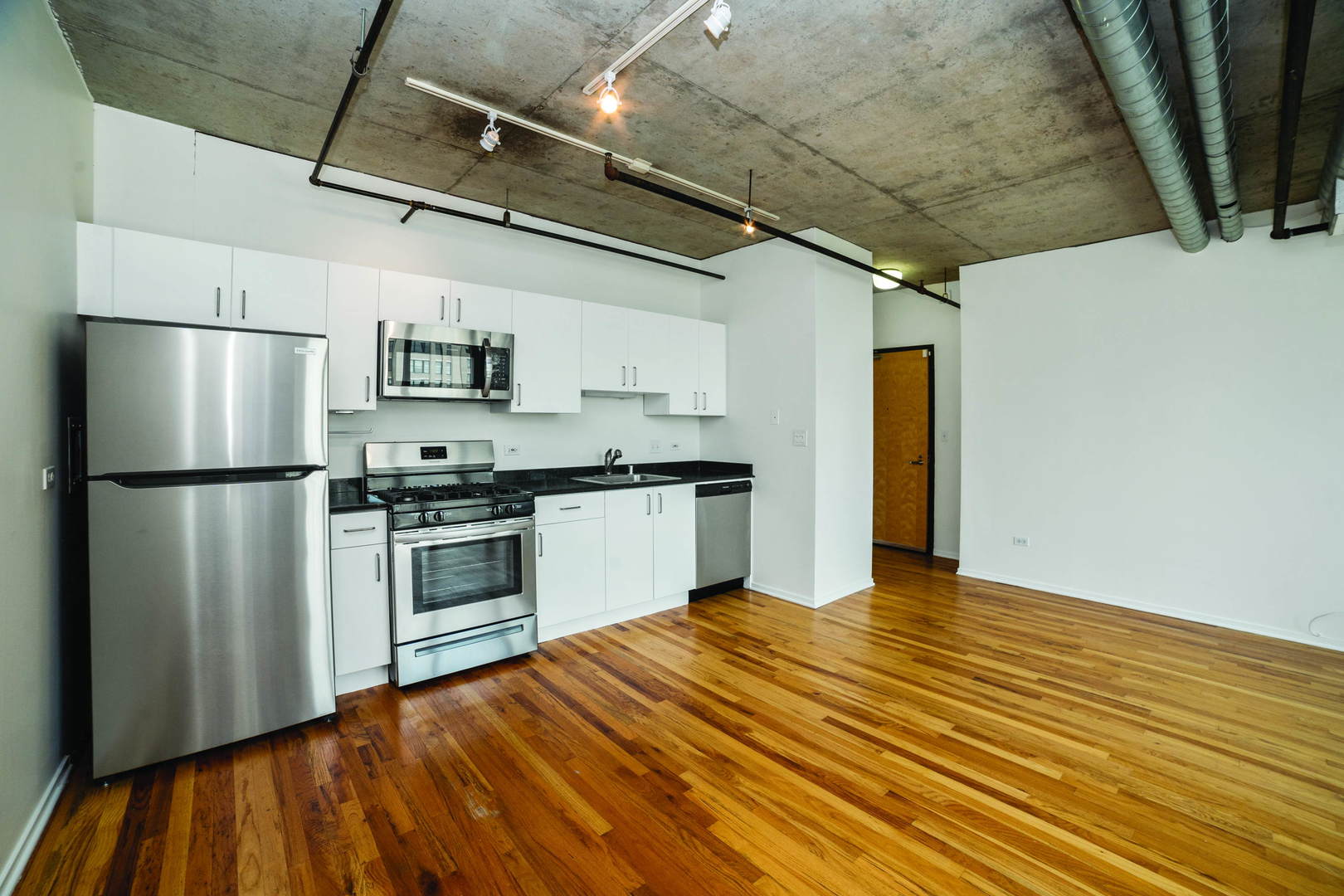 700 West Van Buren Street, Unit 1010 Chicago, IL 60607 - Photo 4 of 12 a kitchen with granite countertop a refrigerator and a stove top oven
