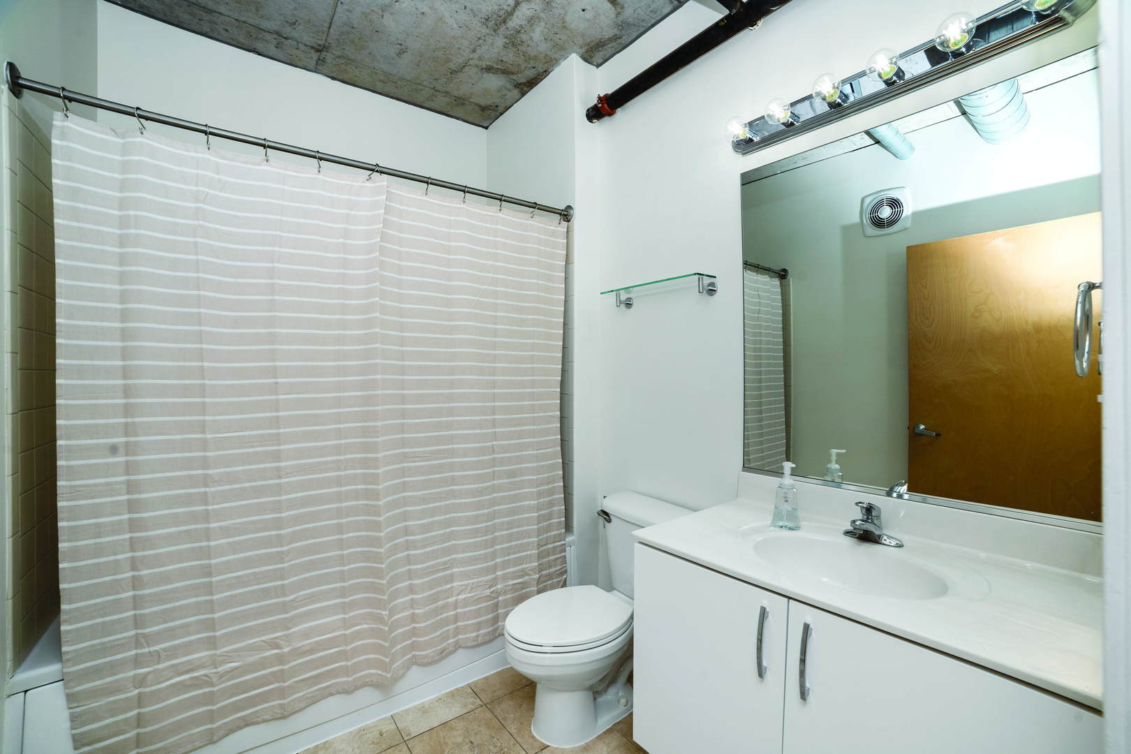 700 West Van Buren Street, Unit 1010 Chicago, IL 60607 - Photo 7 of 12 a bathroom with a sink a toilet and shower