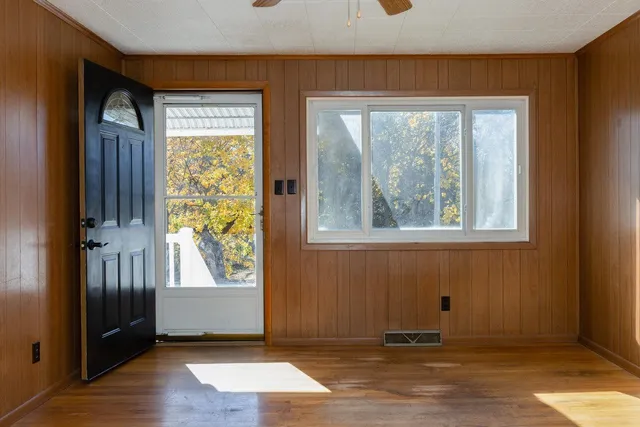 an empty room with wooden floor and windows
