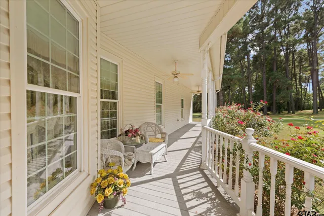 a view of a porch with a floor to ceiling window with a small yard