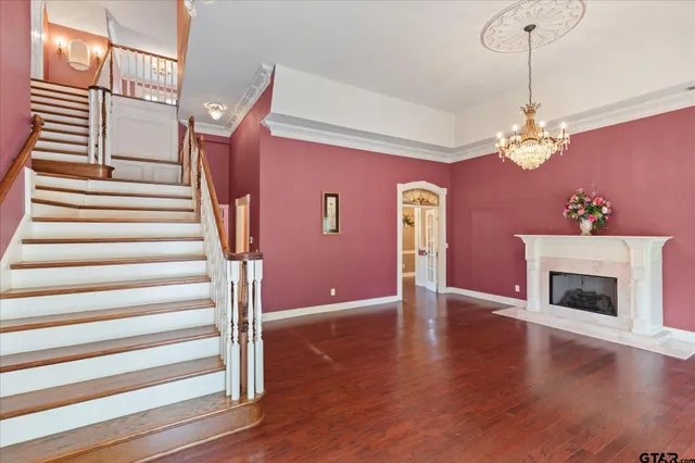a view of a livingroom with a fireplace wooden floor and windows