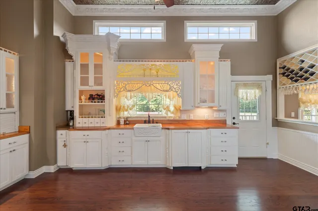 a large kitchen with lot of counter space and wooden floor