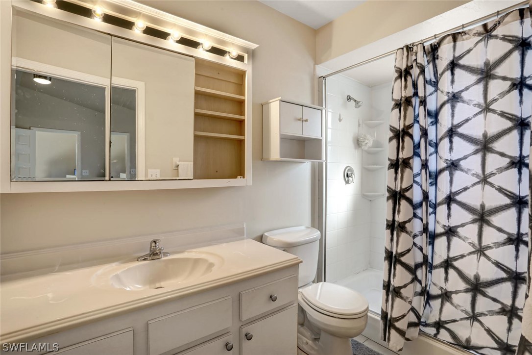 13710 Raleigh Lane, Unit 5 Fort Myers, FL 33919 - Photo 12 of 29 a bathroom with a sink a toilet and shower curtain
