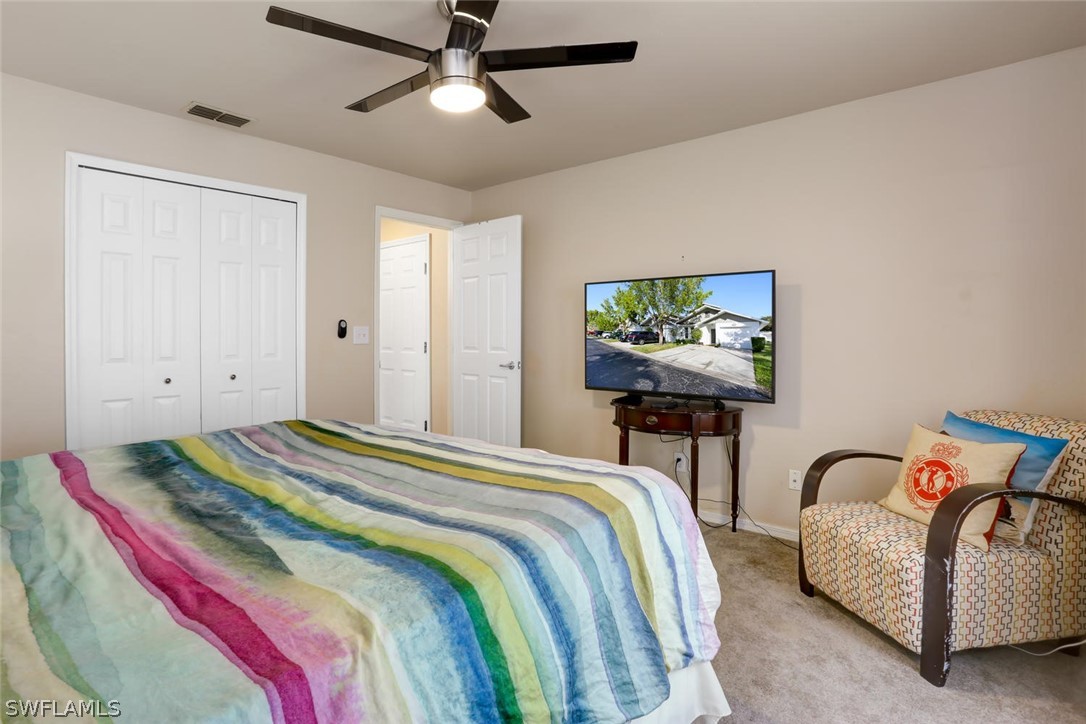 13710 Raleigh Lane, Unit 5 Fort Myers, FL 33919 - Photo 16 of 29 a bedroom with bed and a chandelier