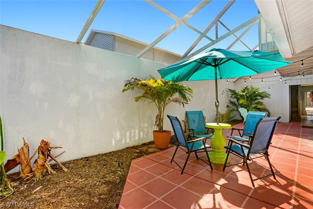 13710 Raleigh Lane, Unit 5 Fort Myers, FL 33919 - Photo 23 of 29 a chair and table under an umbrella
