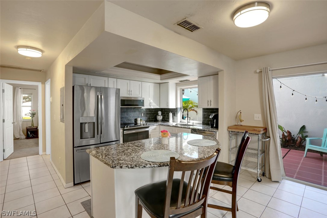 13710 Raleigh Lane, Unit 5 Fort Myers, FL 33919 - Photo 6 of 29 a kitchen with refrigerator and chairs