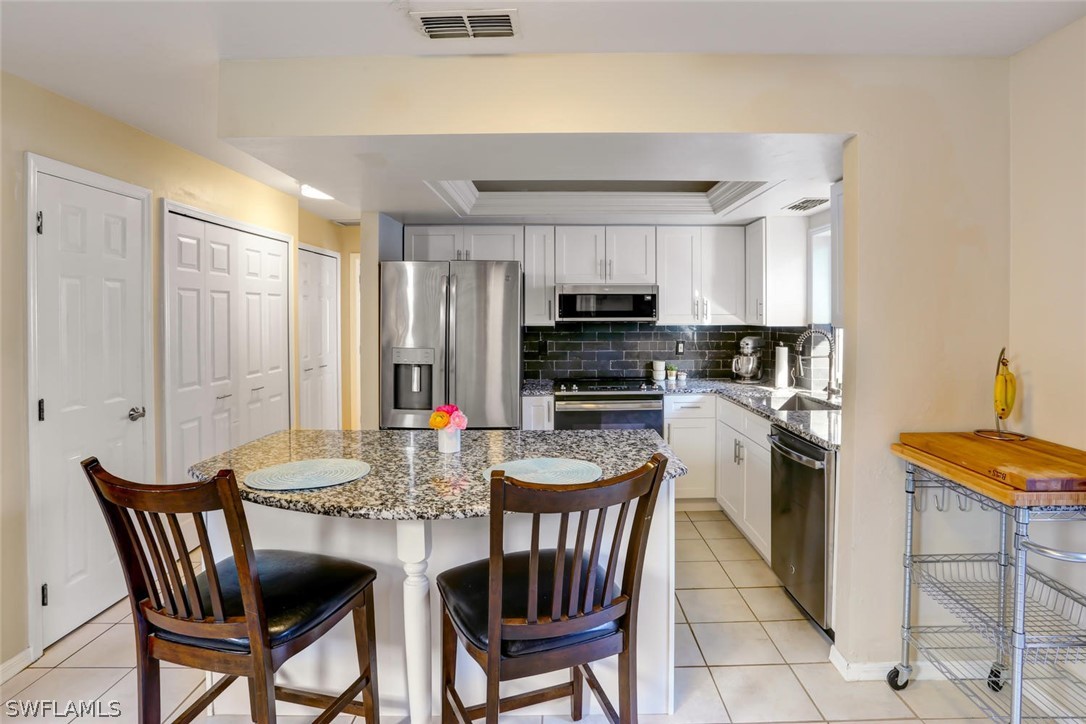 13710 Raleigh Lane, Unit 5 Fort Myers, FL 33919 - Photo 10 of 29 a kitchen with stainless steel appliances granite countertop a kitchen island hardwood floor and a sink